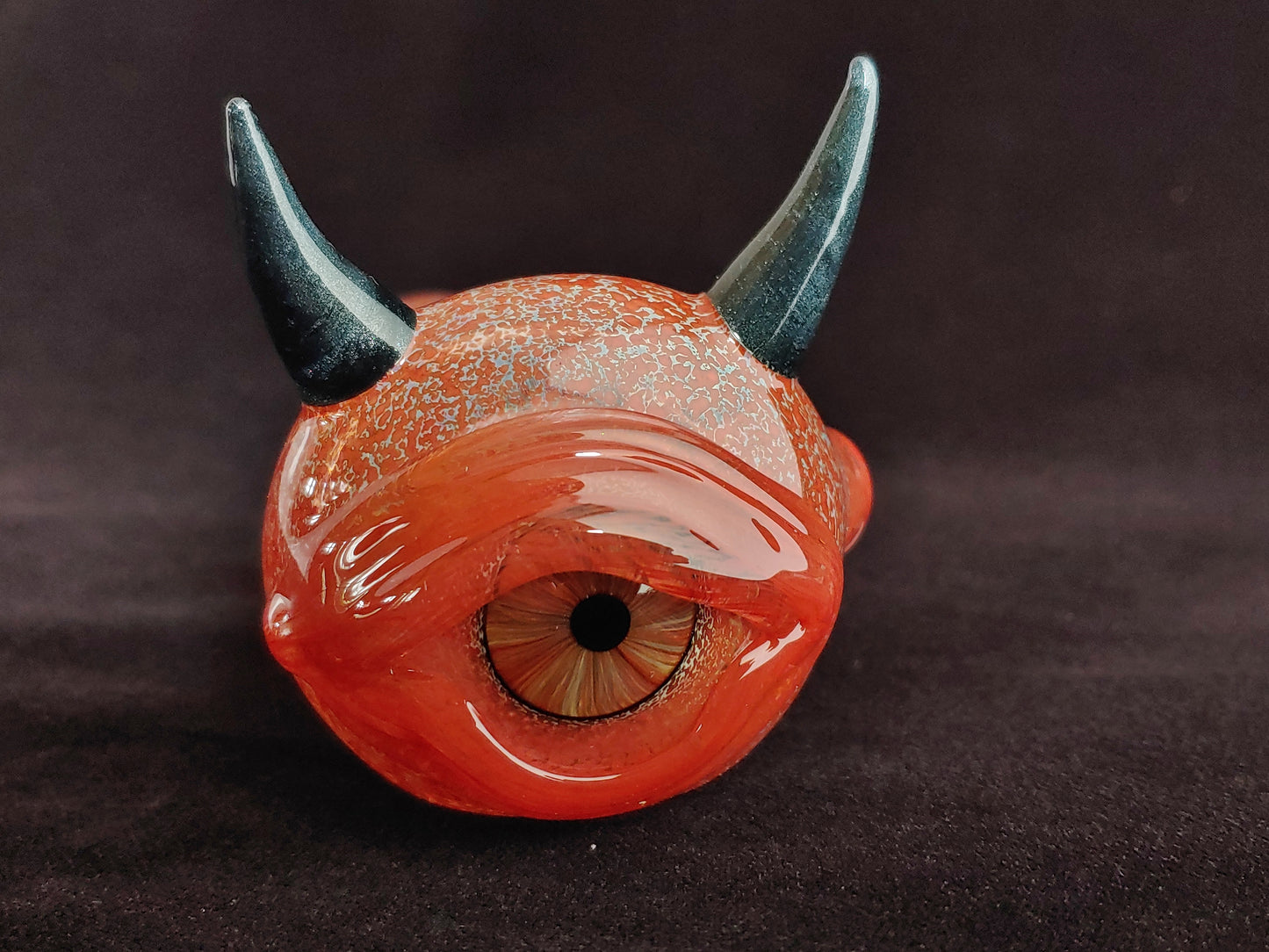Glass pipe with a realistic eyeball and a set of horns.